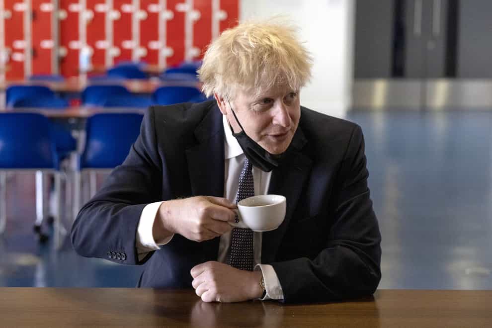 Boris Johnson drinking a cup of tea on a school visit