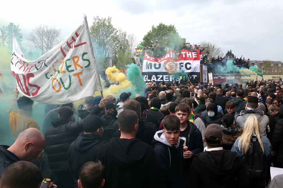 Smoke flares are let off outside Old Trafford as fans protest against the Glazers