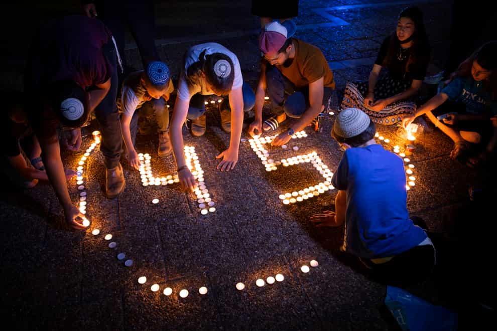 Israeli youths light candles in memory of the 45 ultra-Orthodox Jews killed in a stampede at a religious festival on Friday, during a vigil in Tel Aviv, Israel
