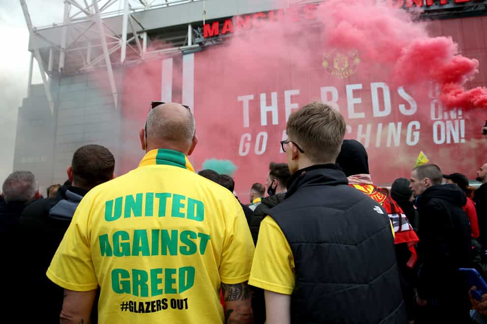 A fan wears a shirt with a “United Against Greed” message on it