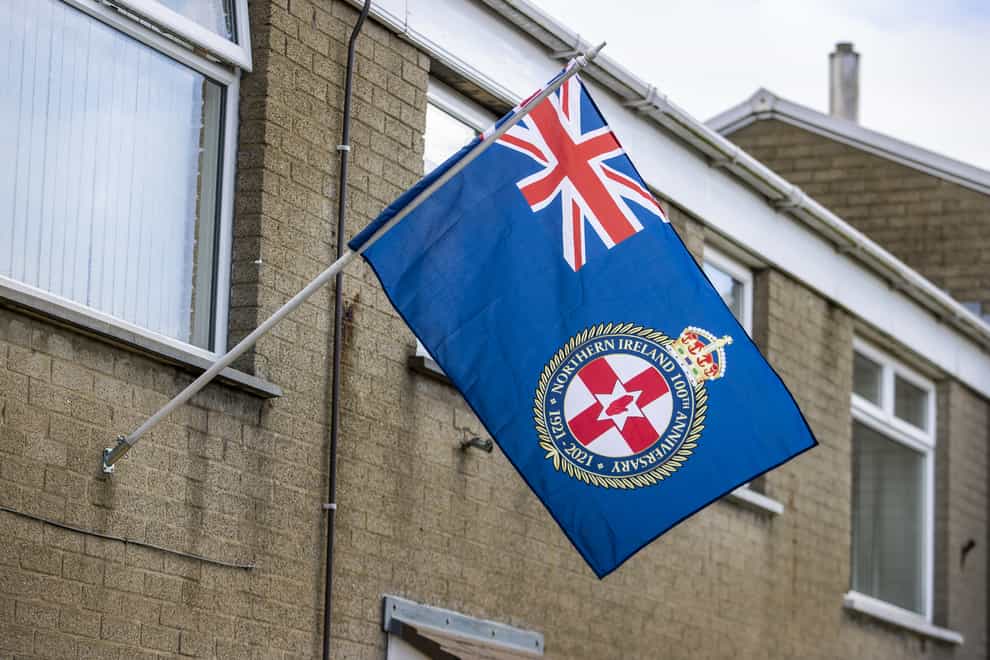 A Northern Ireland 100th Anniversary flag flickers in the wind from a flagpole attached to a house close on the Longstone Road area of Lisburn