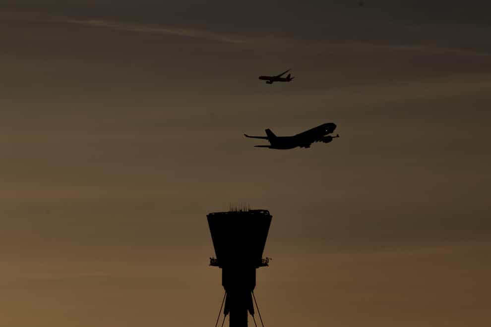 A plane takes off past the control tower at Heathrow Airport (Steve Parsons/PA)