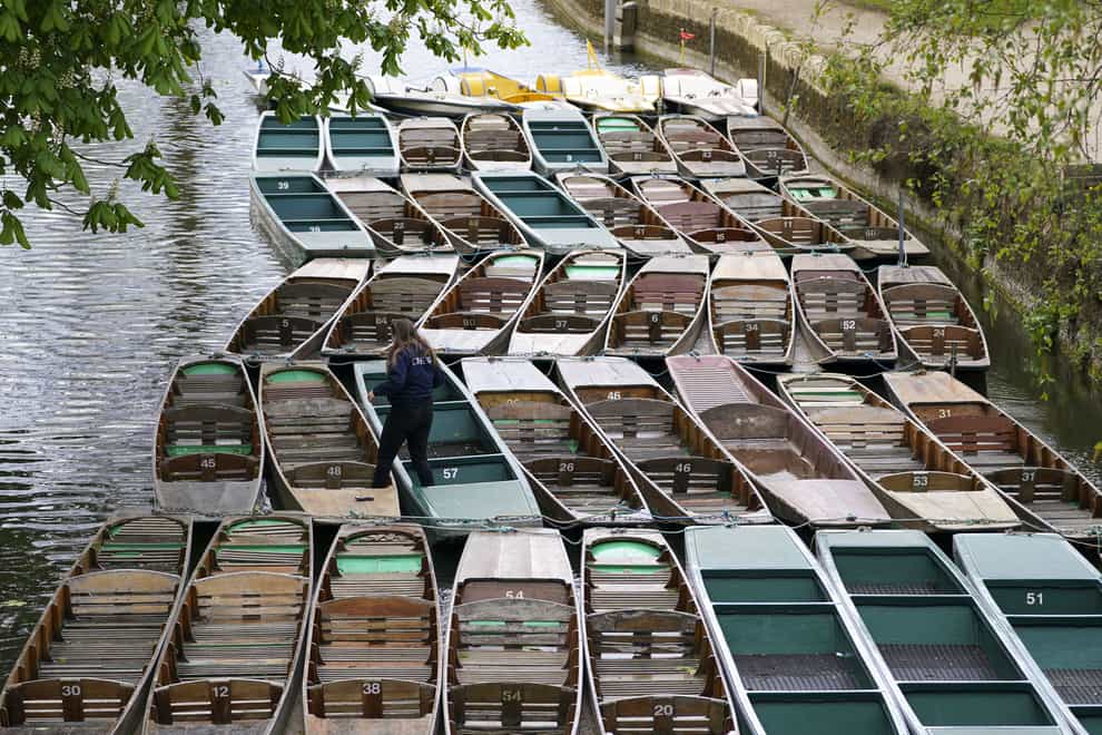 A member of staff maintains punts in Oxford, following the further easing of lockdown restrictions in England (Steve Parsons/PA)