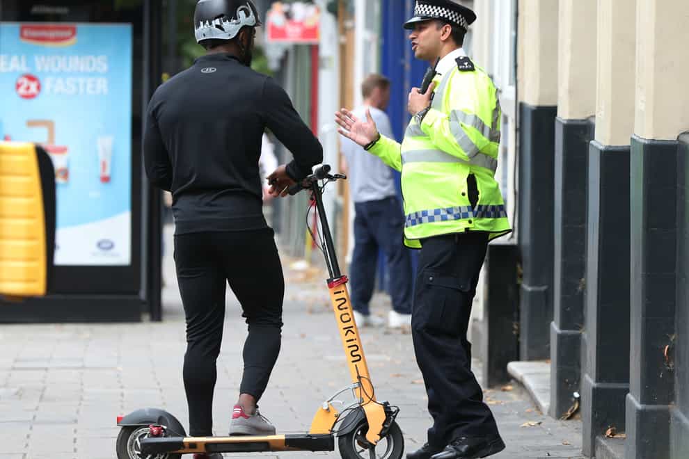 A police officer talks to an e-scooter rider
