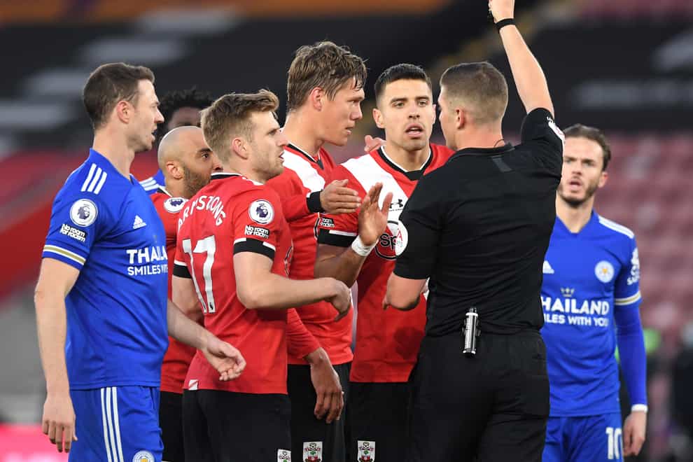 Referee Robert Jones shows a red card to Southampton’s Jannik Vestergaard (centre)