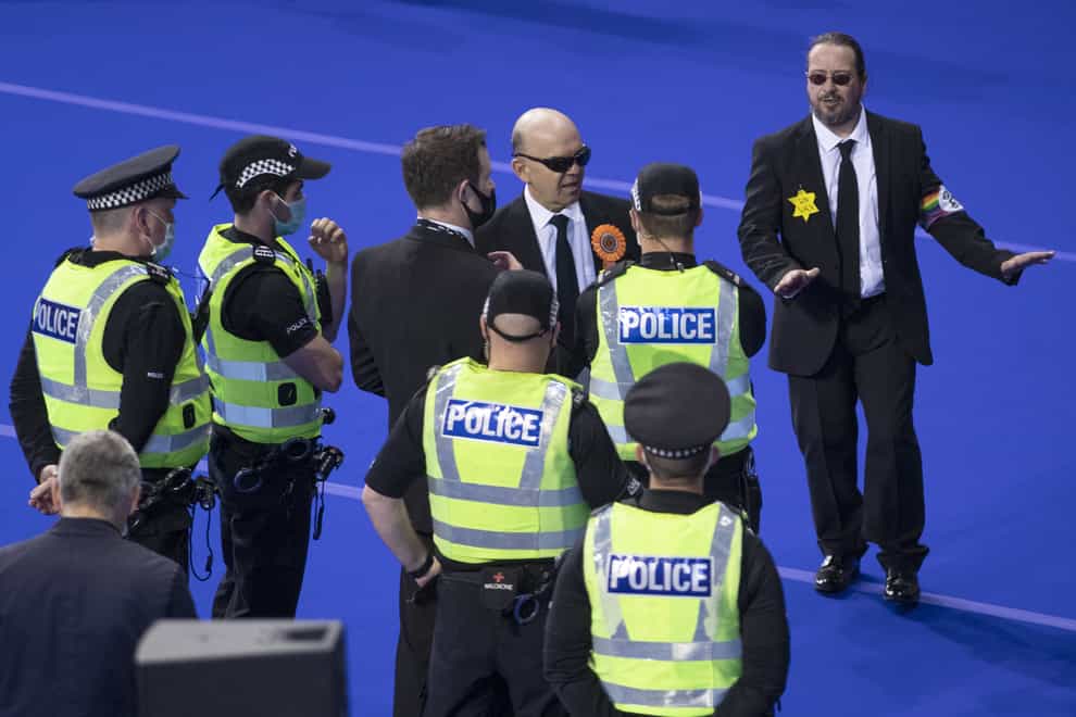 Police speak with members of the Liberal Party before they are removed from the count floor