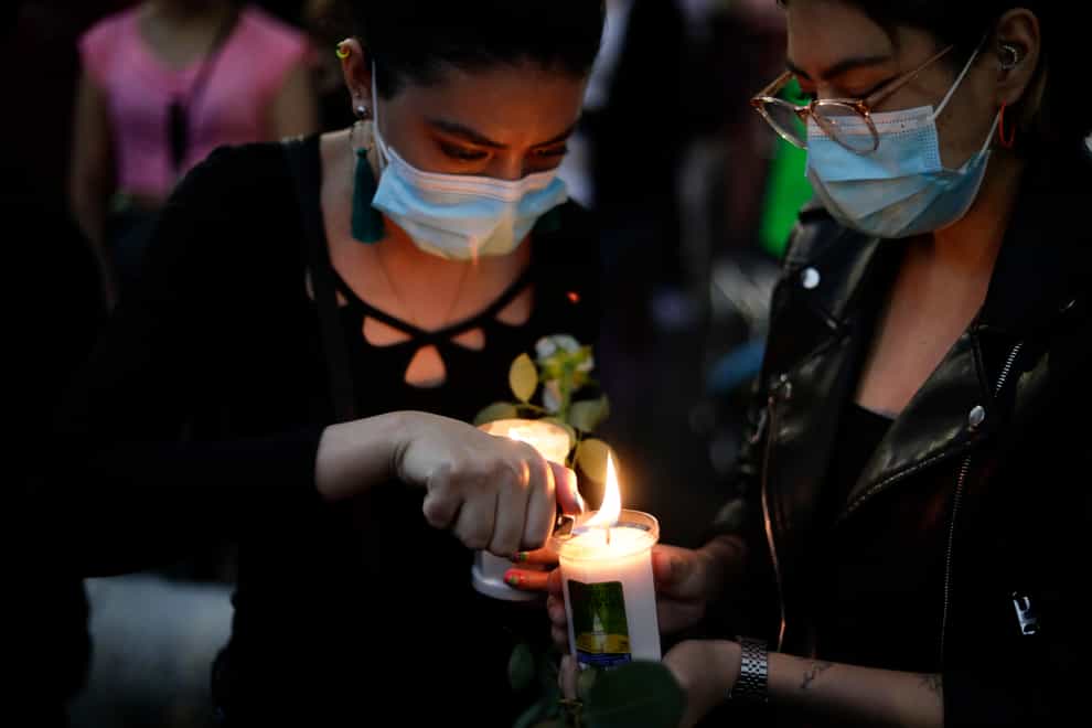 A woman lights a candle during a march demanding justice for the people who died in Monday’s subway collapse, in Mexico City’s south side