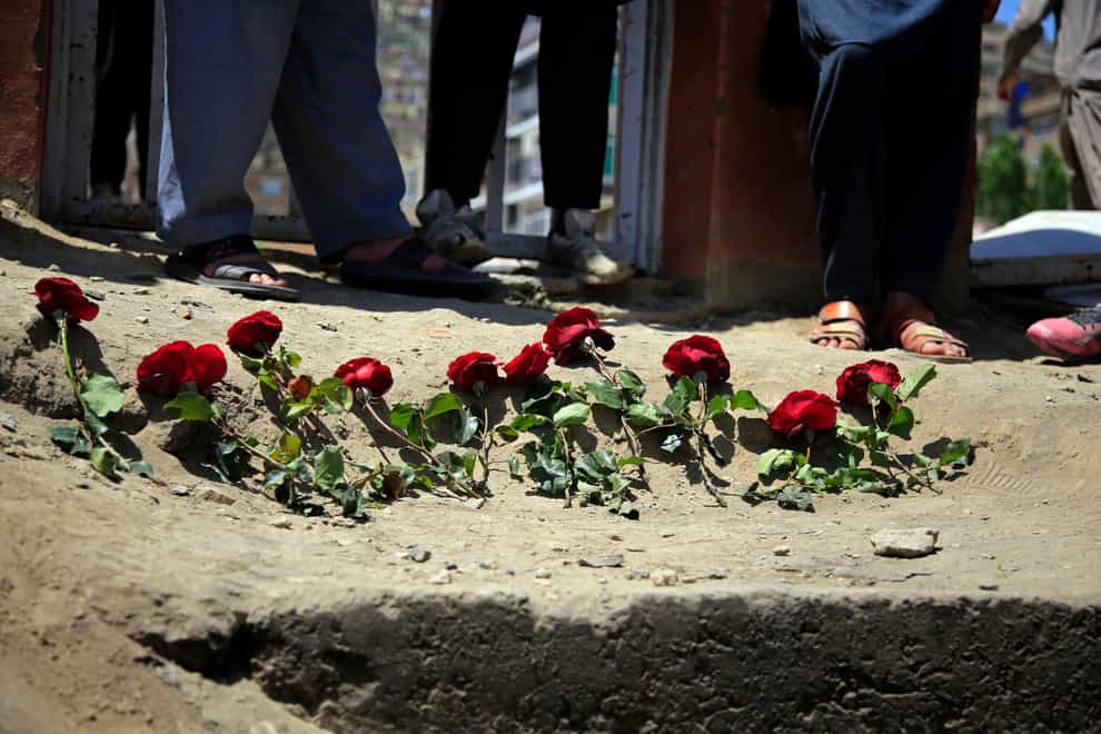 People puts flowers outside a school after a deadly attack on Saturday, in Kabul, Afghanistan