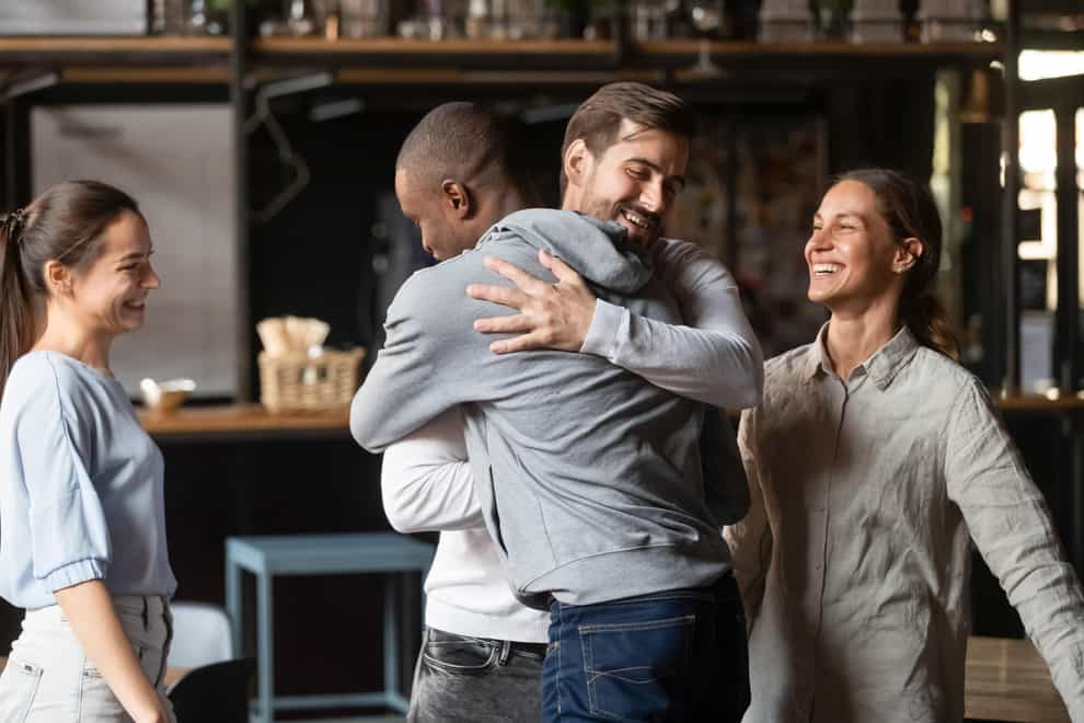 Two friends hugging in a restaurant
