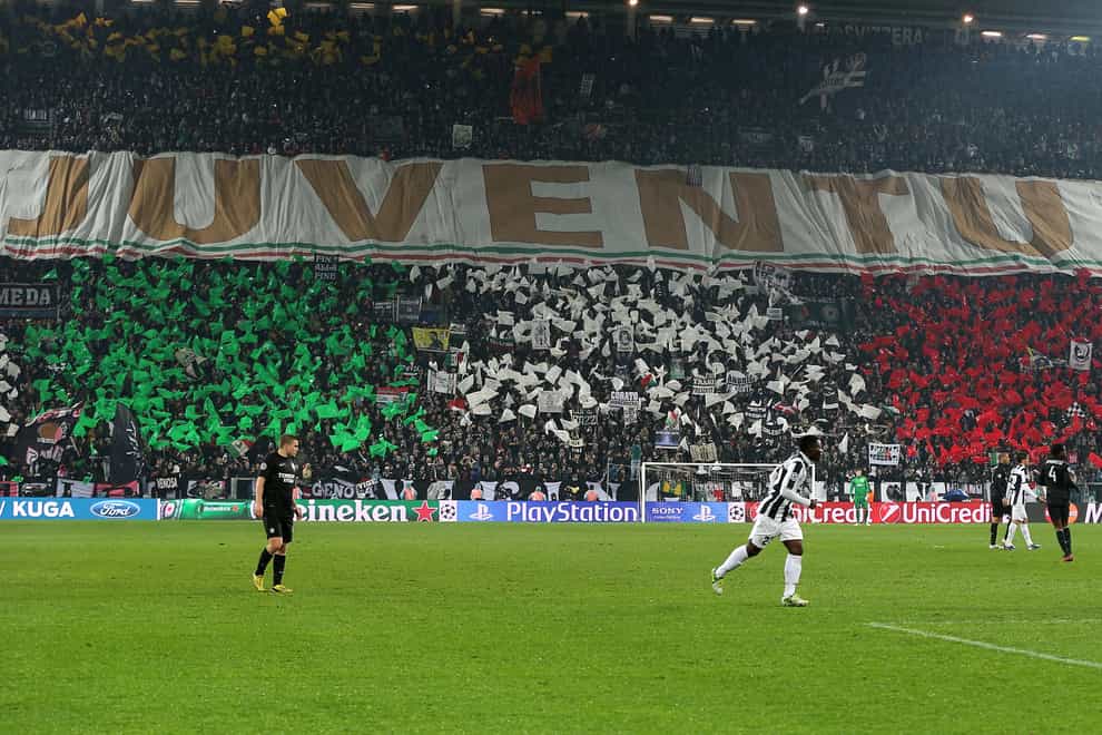 Juventus fans hold a giant banner and flags bearing the colours of the Italian national flag