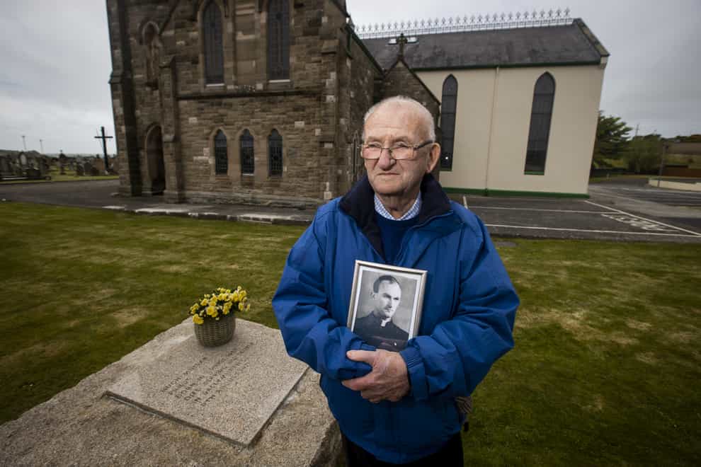 Patsy Mullan, brother of Father Hugh Mullan, visits his grave