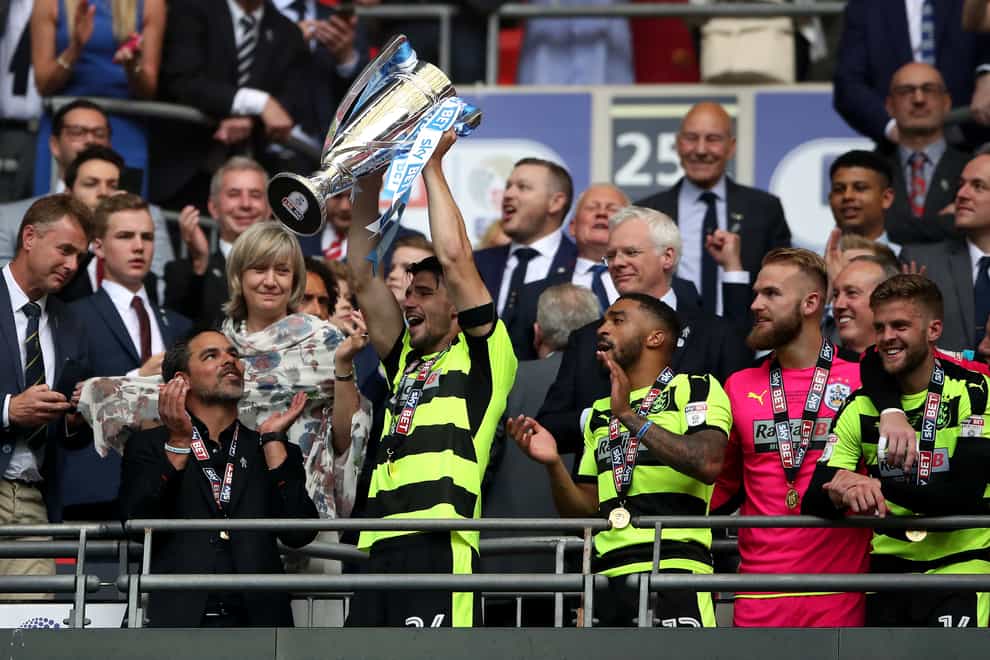 Christopher Schindler, holding trophy, helped Huddersfield win promotion to the Premier League via the play-offs in 2017