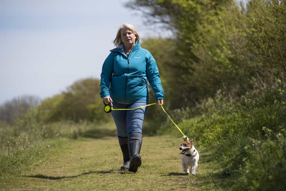 An actress playing the role of PCSO Julia James walks her Jack Russell dog Toby
