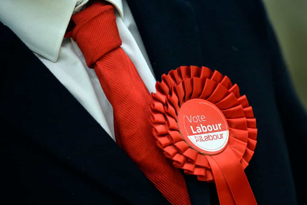 A Labour Party supporter wears a rosette (Hannah McKay/PA)