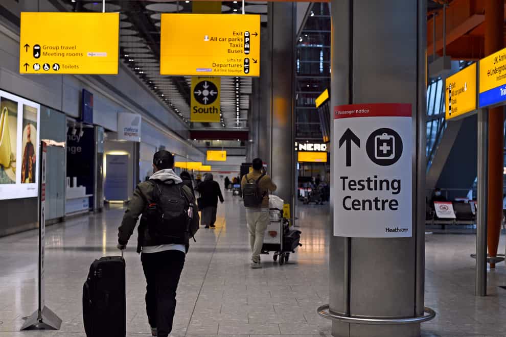 A passenger walks past a sign for the Covid testing centre in Heathrow's Terminal 5