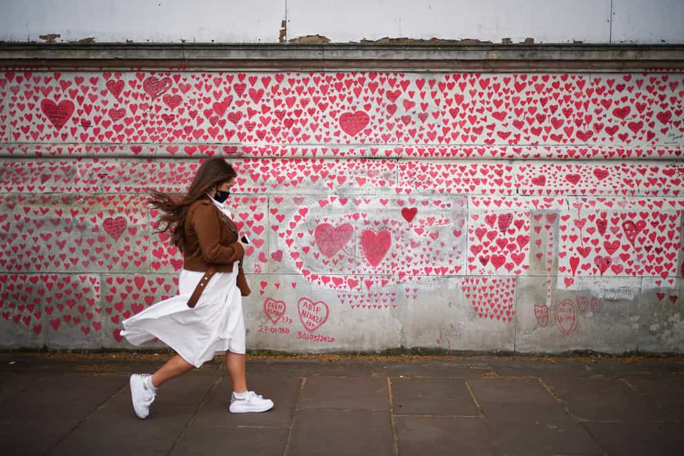 A woman walks past the National Covid Memorial Wall