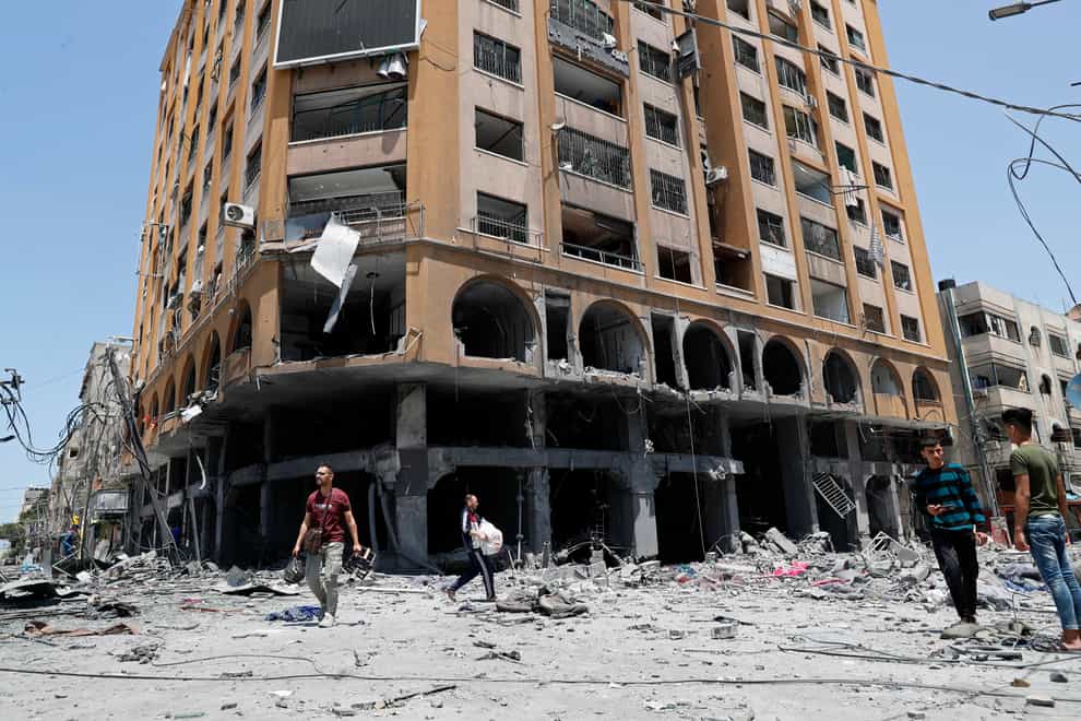 People inspect the rubble of a damaged building which was hit by an Israeli air strike in Gaza City