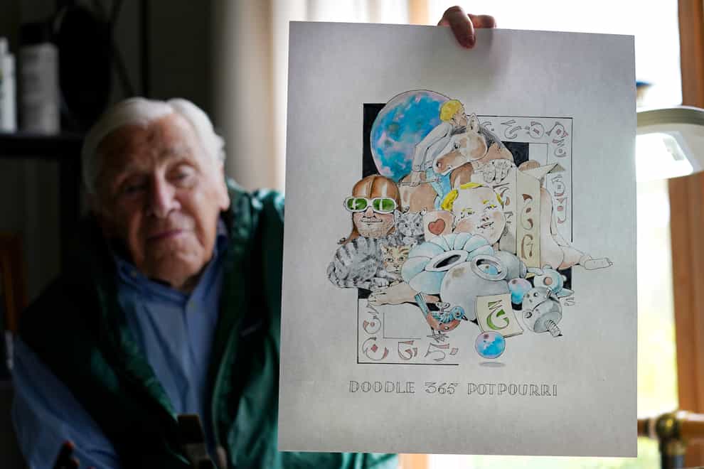 Artist Robert Seaman holds up the 365th daily doodle sketch in his room at an assisted living facility in Westmoreland, New Hampshire
