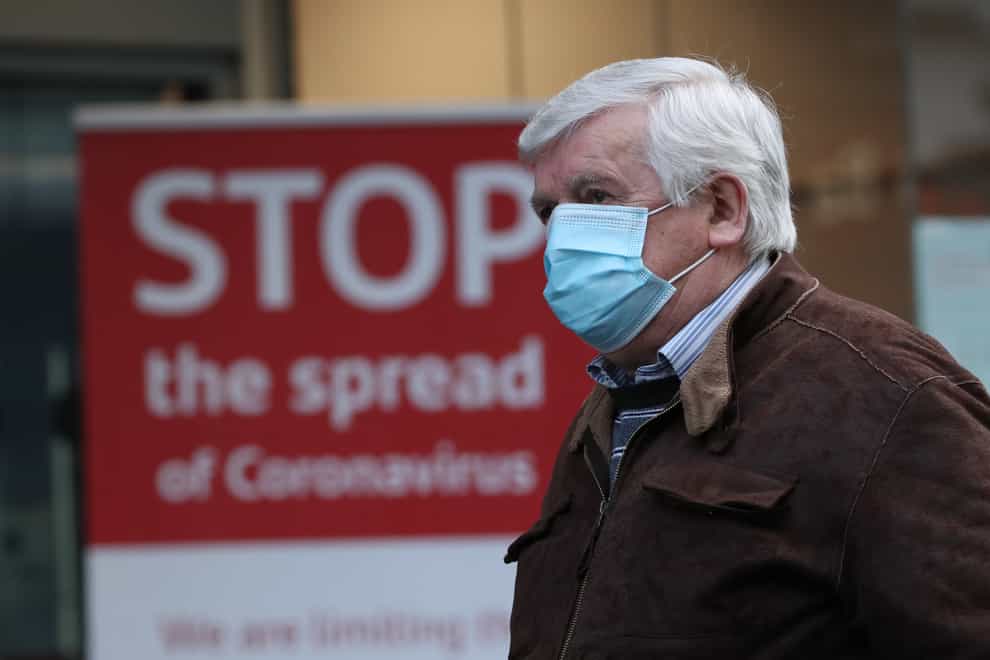 Man walking past coronavirus sign