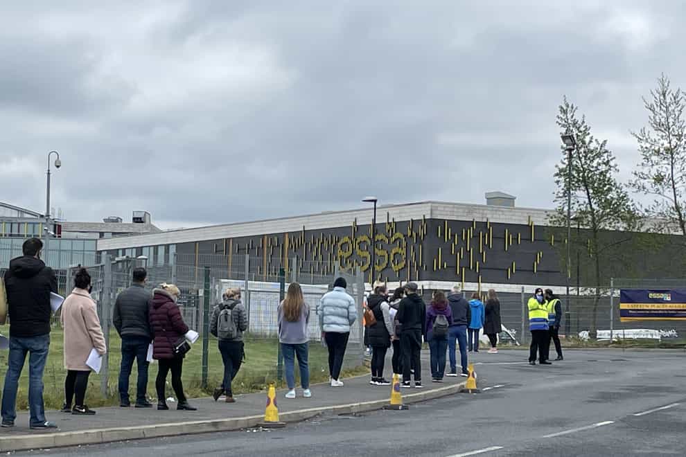 People queue for the vaccination centre at the Essa Academy in Bolton