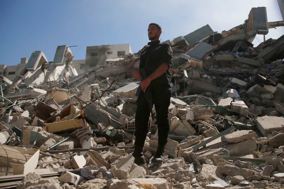A policeman stands in the rubble of the building that housed The Associated Press offices in Gaza City