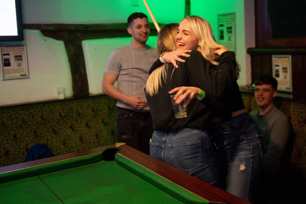 Customers enjoy a game of pool and a hug at the The Oak Inn in Coventry (Jacob King/PA)