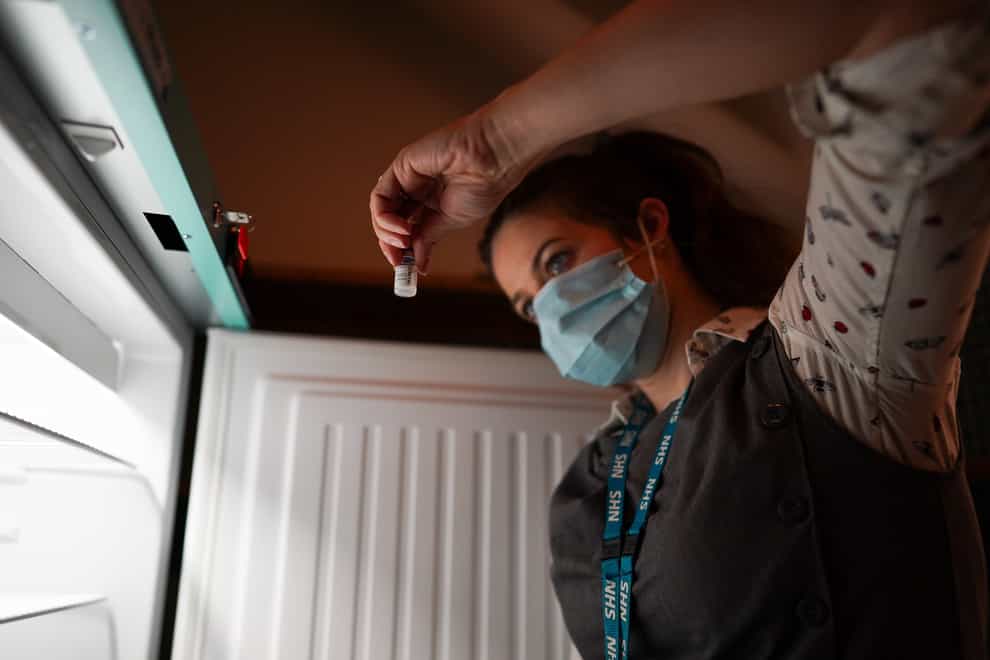 Pharmacist Ciara Duffy removes Pfizer BioNTech Covid-19 vaccines from a fridge