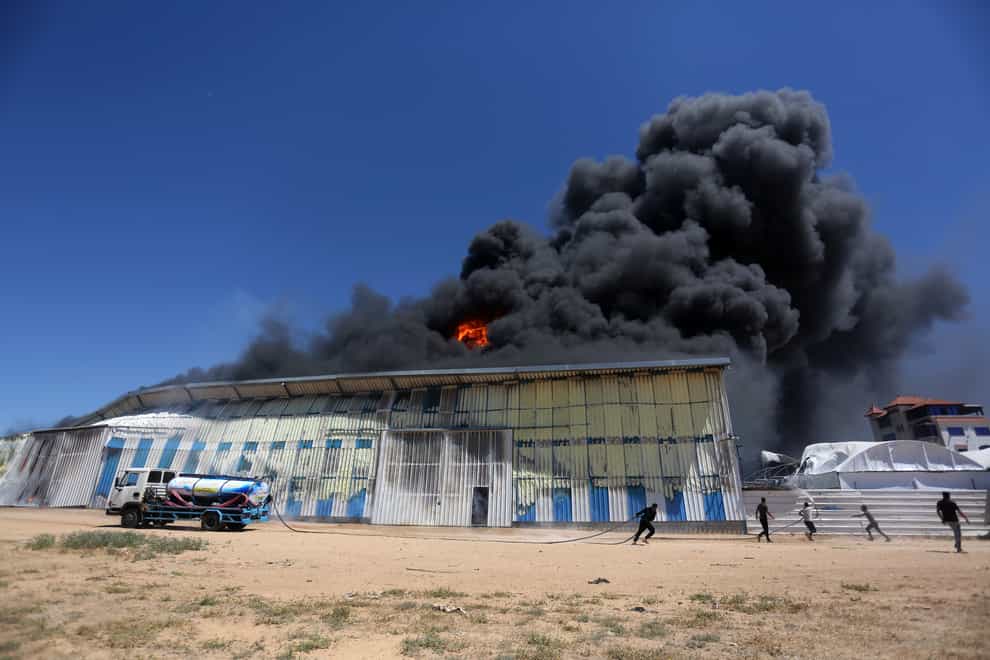 Palestinians use a water tanker to try to extinguish a fire at a paint factory after it was hit by an Israeli airstrike, in Rafah, Gaza Strip (Yousef Masoud/AP)