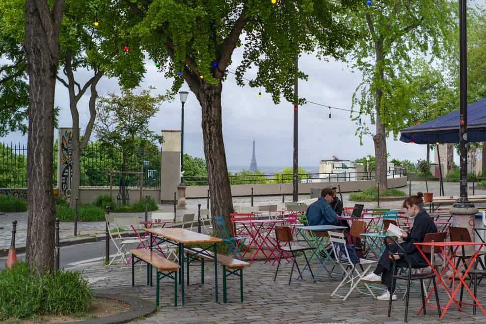 Customers sit at tables at a cafe terrace in Paris (Rafael Yaghobzadeh/AP)