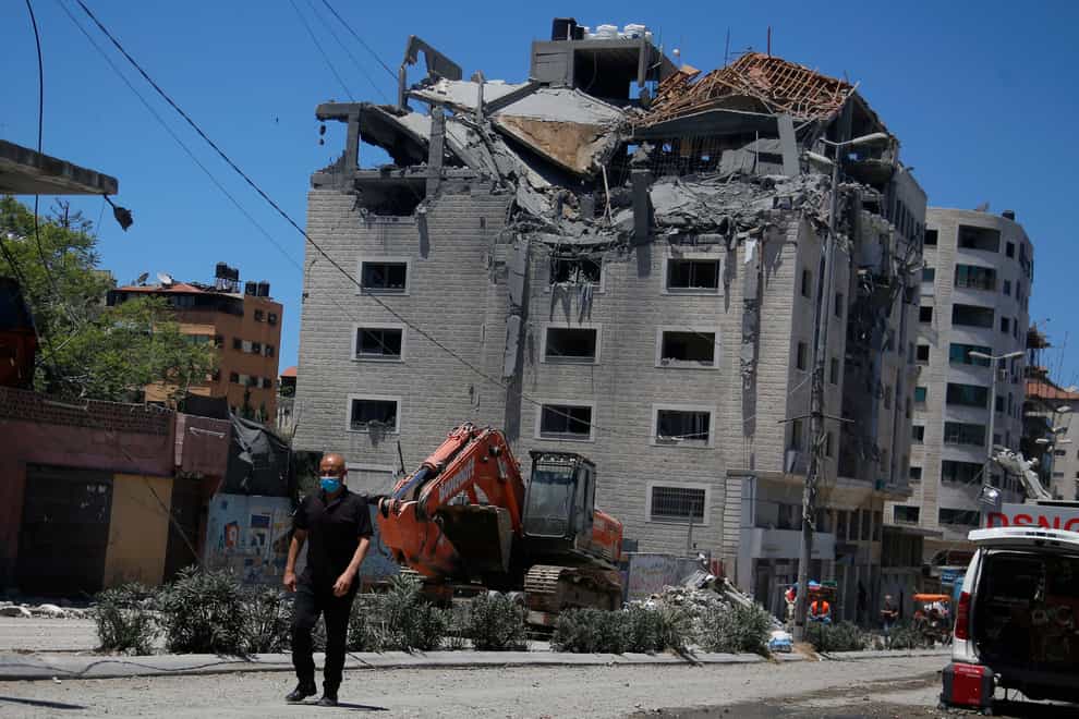 A Palestinian walks by a building hit by an Israeli air strike in Gaza City