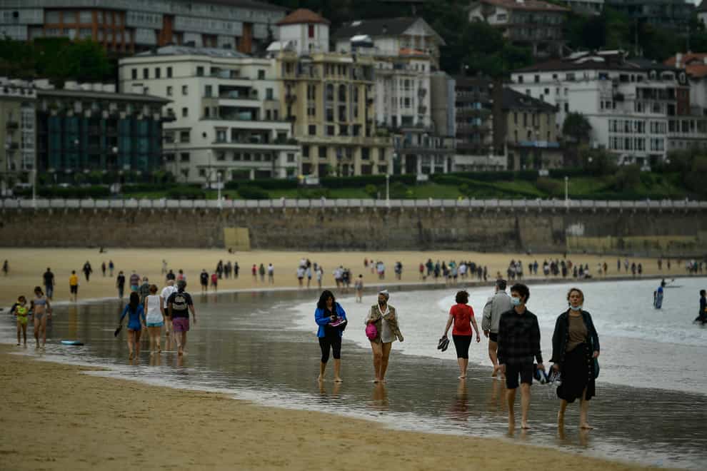 People walk along La Concha beach in San Sebastian, northern Spain