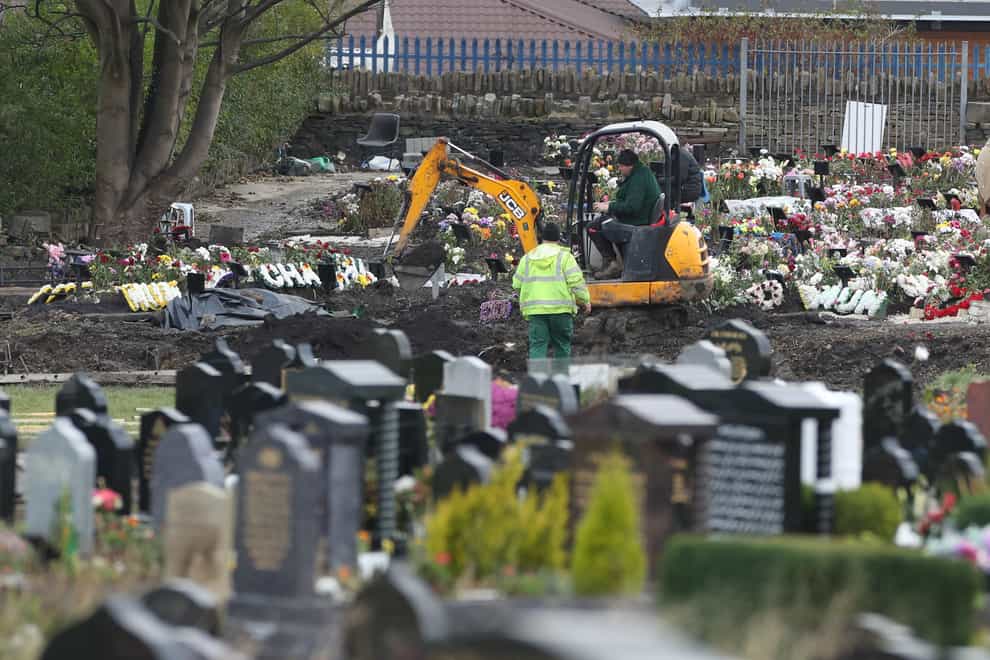 Workers use machinery to dig graves next to the Muslim burial ground at the Scholemoor Cemetery and Crematorium, in Bradford, West Yorkshire (Danny Lawson/PA)
