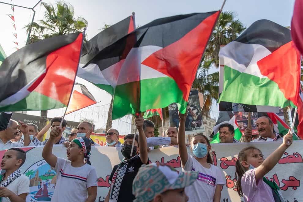 Children wave Palestinian flags during a protest supporting the children in Gaza, in the West Bank city of Ramallah