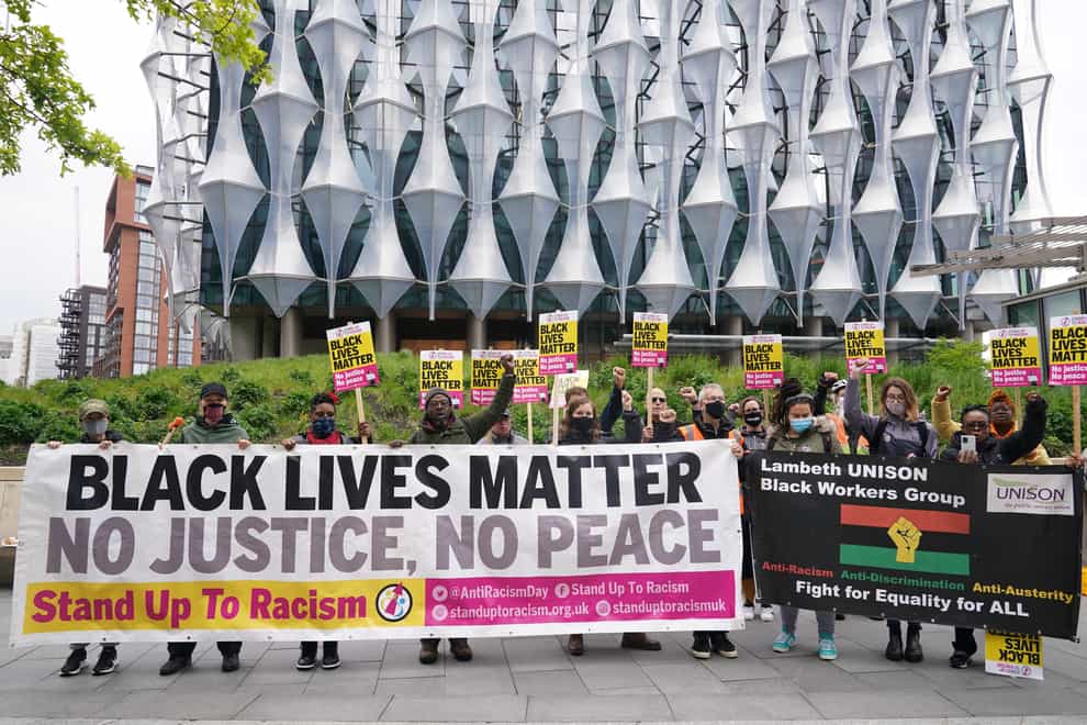 People take part in a BLM protest to commemorate the death of George Floyd outside the US Embassy in London