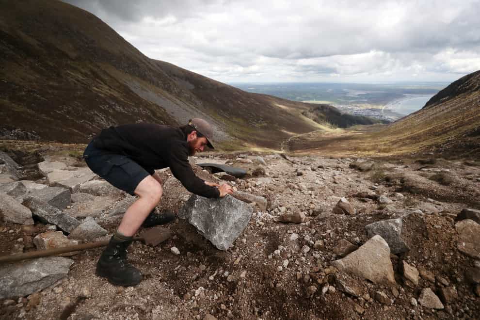 National Trust mountain ranger Theo Burke trails heavy slabs up Slieve Donard