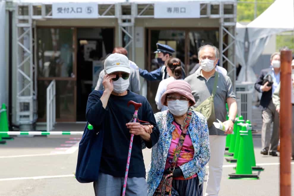 Elderly people go out of the newly opened mass vaccination centre after receiving the Moderna coronavirus vaccine in Tokyo