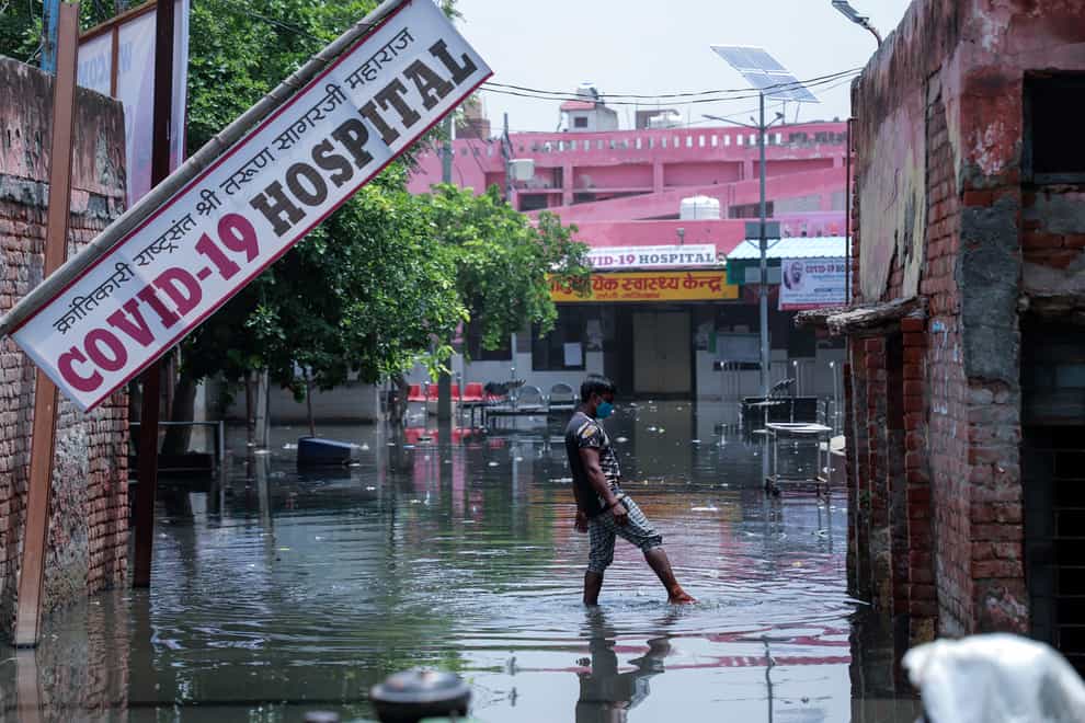 A worker tries to clear water after heavy rains flooded the premises of a Covid-19 hospital being set up at Ghaziabad, on the outskirts of New Delhi, India