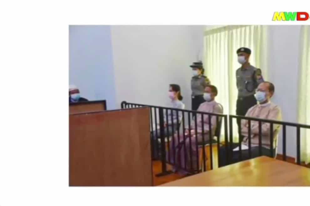 In this image from Myawaddy TV, a photograph shown during a news report showing the appearance of deposed Myanmar leader Aung San Suu Kyi, former president Win Myint, sitting 3rd from right, and former Naypyitaw Council chairman Dr. Myo Aung before a special court, shown while a report about Suu Kyi’s case is read by a news presenter in Naypyitaw, Myanmar