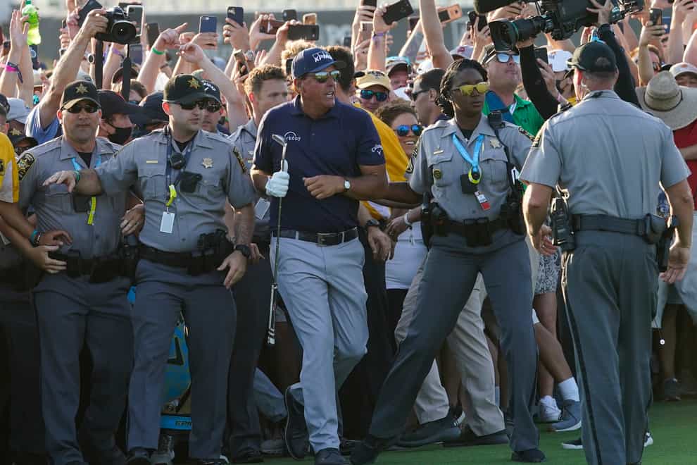 Phil Mickelson wades through fans on the 18th fairway