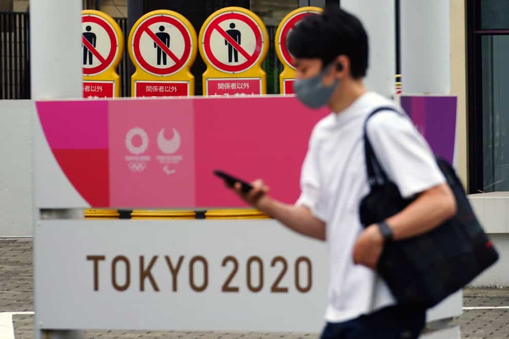 A man walks past a banner for the Tokyo 2020 Olympic and Paralympic Games in Tokyo