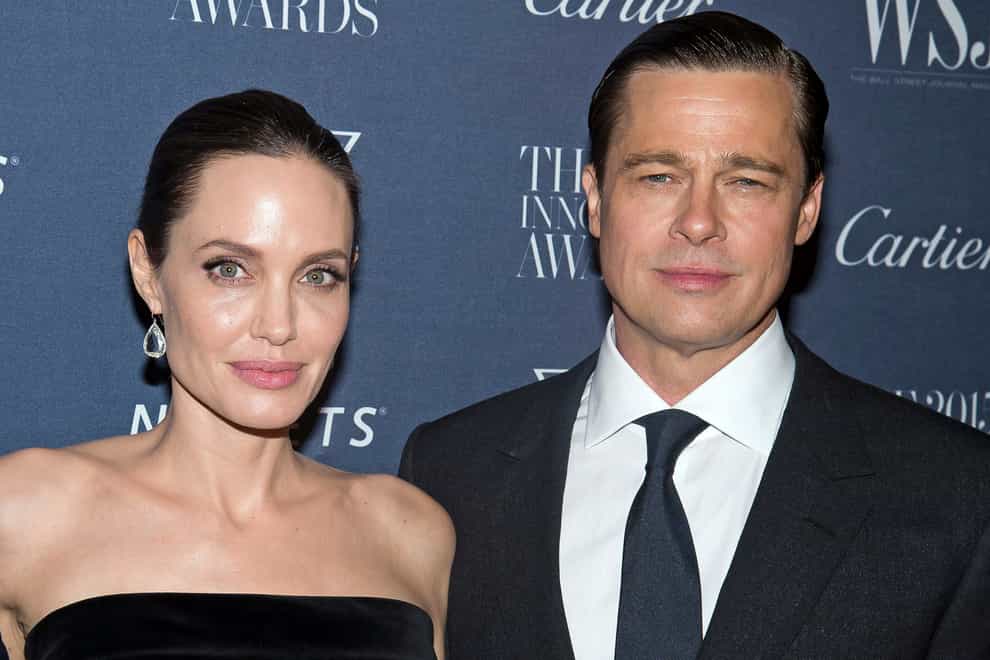 Angelina Jolie Pitt and Brad Pitt pose for a photo at an awards ceremony in 2015