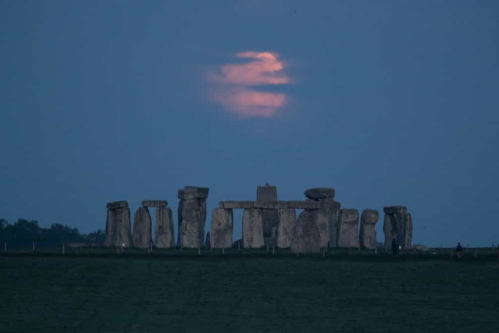 The Flower supermoon sets behind Stonehenge in Wiltshire
