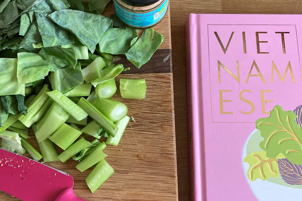 Chopped greens next to a copy of Vietnamese: Simple Vietnamese Food To Cook To Home