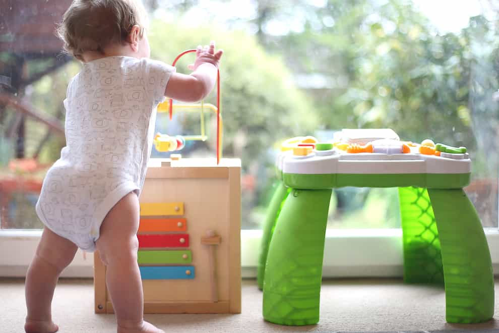 A baby boy playing with an activity table