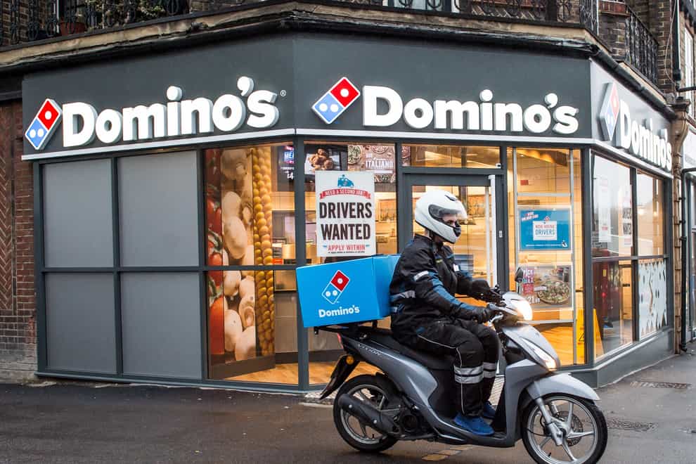 A delivery rider outside a branch of Domino’s Pizza