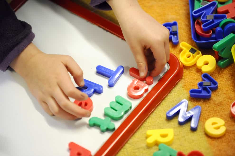 A child plays with magnetic letters