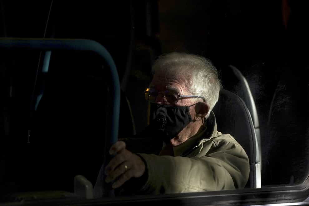 A man wears a mask on a bus