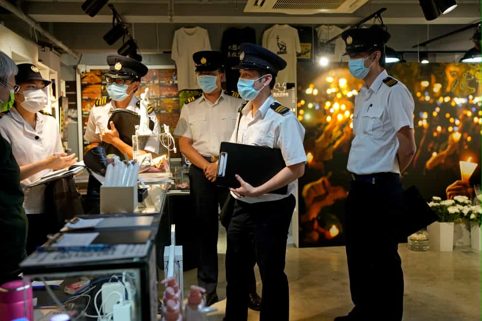 Officers from the Food and Environmental Hygiene Department ask questions to a staff, left, at the June 4 Memorial Museum in Hong Kong