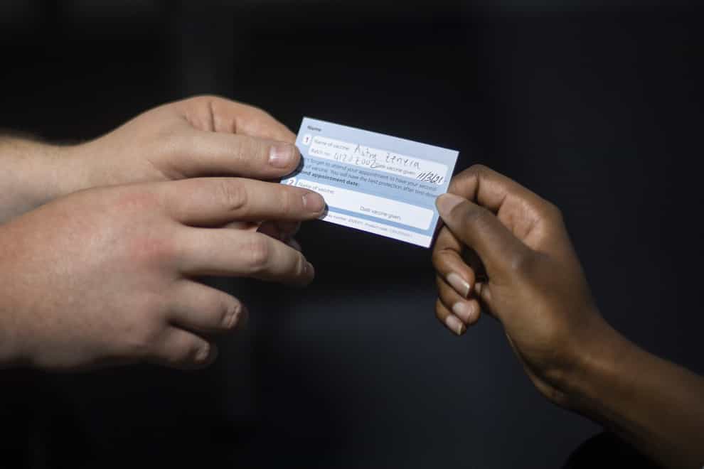 A woman receives a vaccination card after being given an injection of the COVID-19 vaccine at the Science Museum in London, which has been opened as a Covid-19 vaccination centre. (Victoria Jones/PA)