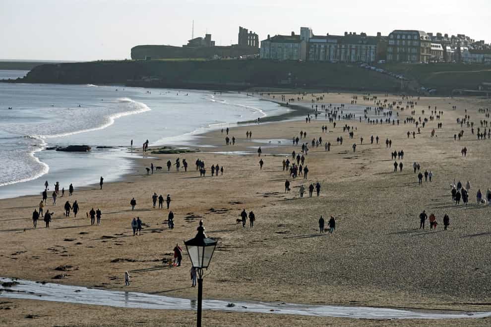 People walking on Tynemouth beach, Tyne and Wear (Owen Humphreys/PA)
